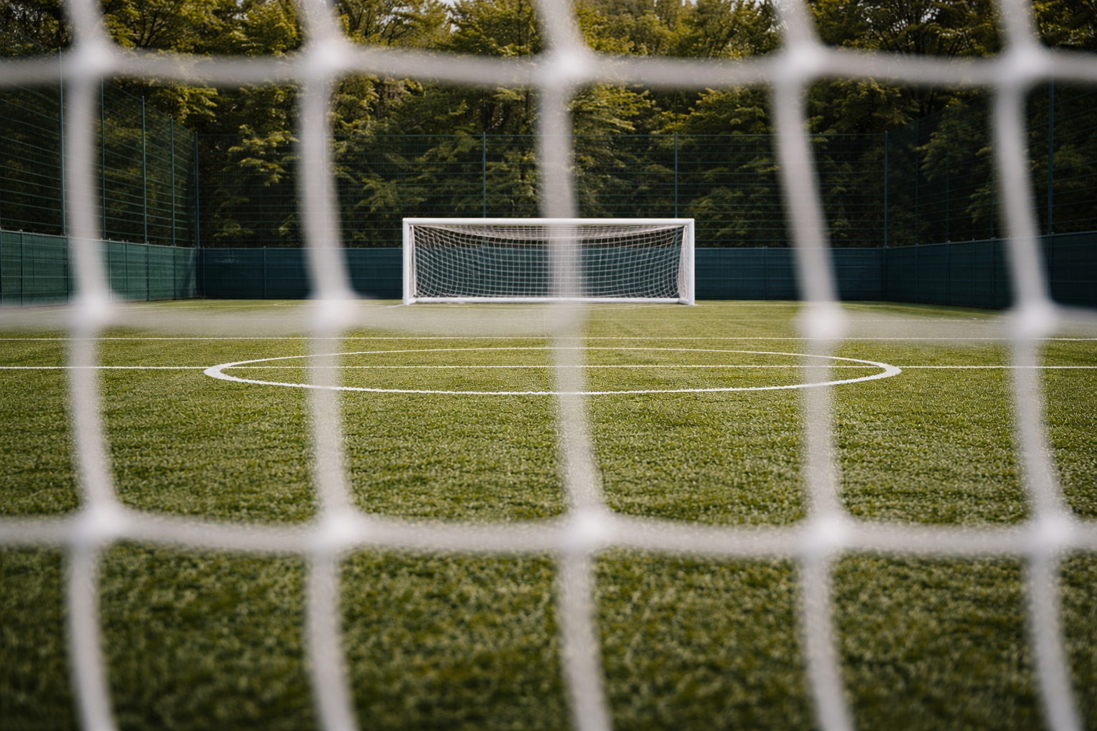 Five-a-side football goal on artificial astro turf pitch viewed through net